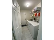 The inside laundry room. The door you see which is closed leads into the garage. - Single Family Home for sale at 18506 Hottelet Cir, Port Charlotte, FL 33948 - MLS Number is C7452138