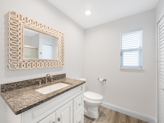 The guest bathroom is conveniently located next to the guest bedrooms and features a large vanity with granite countertop. - Single Family Home for sale at 3070 Hatton St, Sarasota, FL 34237 - MLS Number is A4518301
