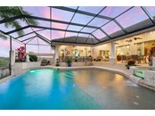Large salt gas heated pool with sun deck and spa is beautifully lit as evening falls - Single Family Home for sale at 1012 Bayview Dr, Nokomis, FL 34275 - MLS Number is A4521028