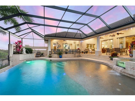 Large salt gas heated pool with sun deck and spa is beautifully lit as evening falls - Single Family Home for sale at 1012 Bayview Dr, Nokomis, FL 34275 - MLS Number is A4521028